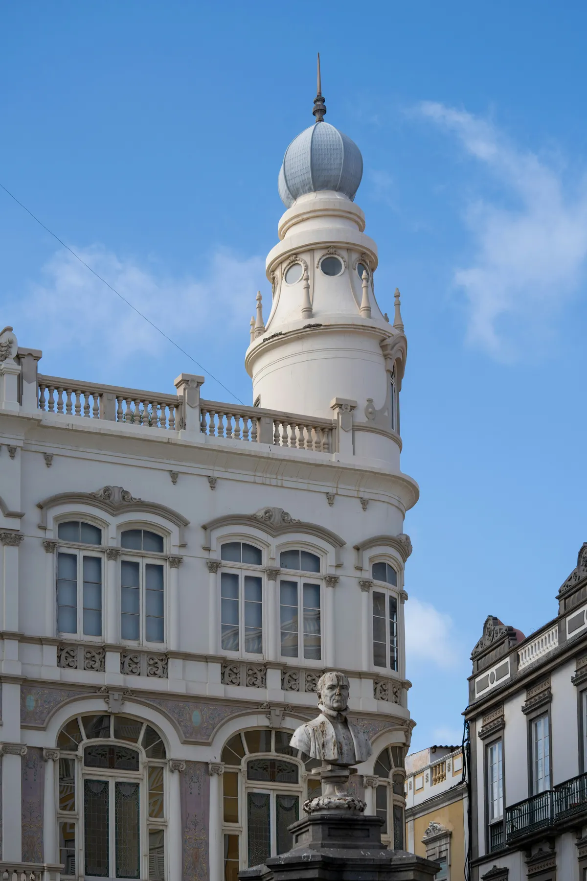 The white Gabinete Literario building with its dome, and a bust in Plaza de Cairasco